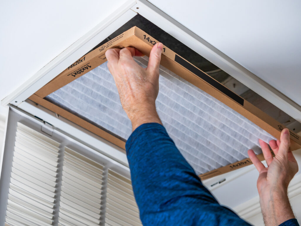 HVAC technician replacing a home air filter in Newport Beach