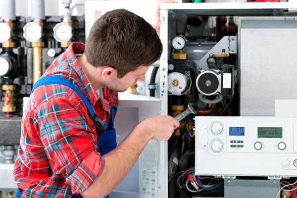 Heating technician repairing boiler controls in Newport Beach