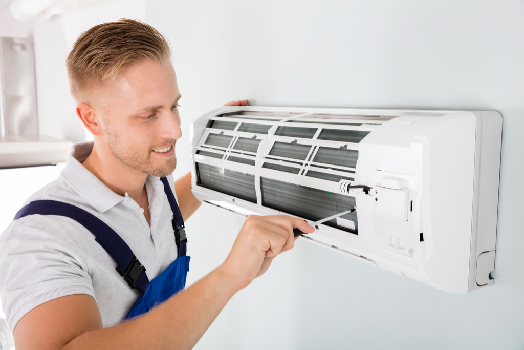 HVAC technician maintaining a ductless air conditioner in Newport Beach