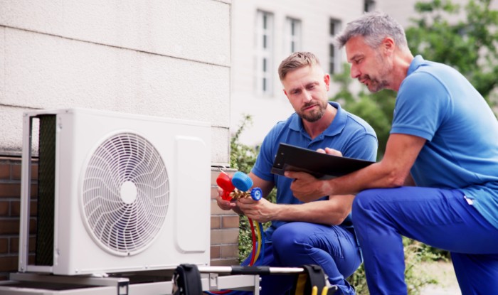 HVAC technicians installing an outdoor air conditioning unit in Newport Beach